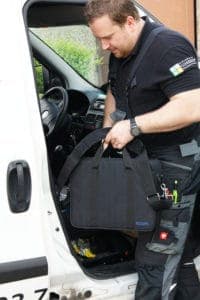 Mann packt Rauchgasanalysegerät von ecom in ein Auto