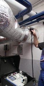 Mann führt eine Rauchgasanalyse mithilfe des mobilen Rauchgasanalysators von ecom durch