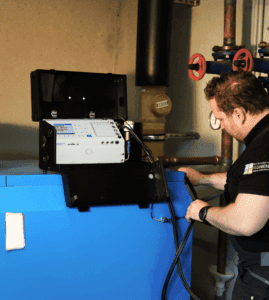 Ein Mann führt eine Rauchgasanalyse mit einem Produkt von ecom durch